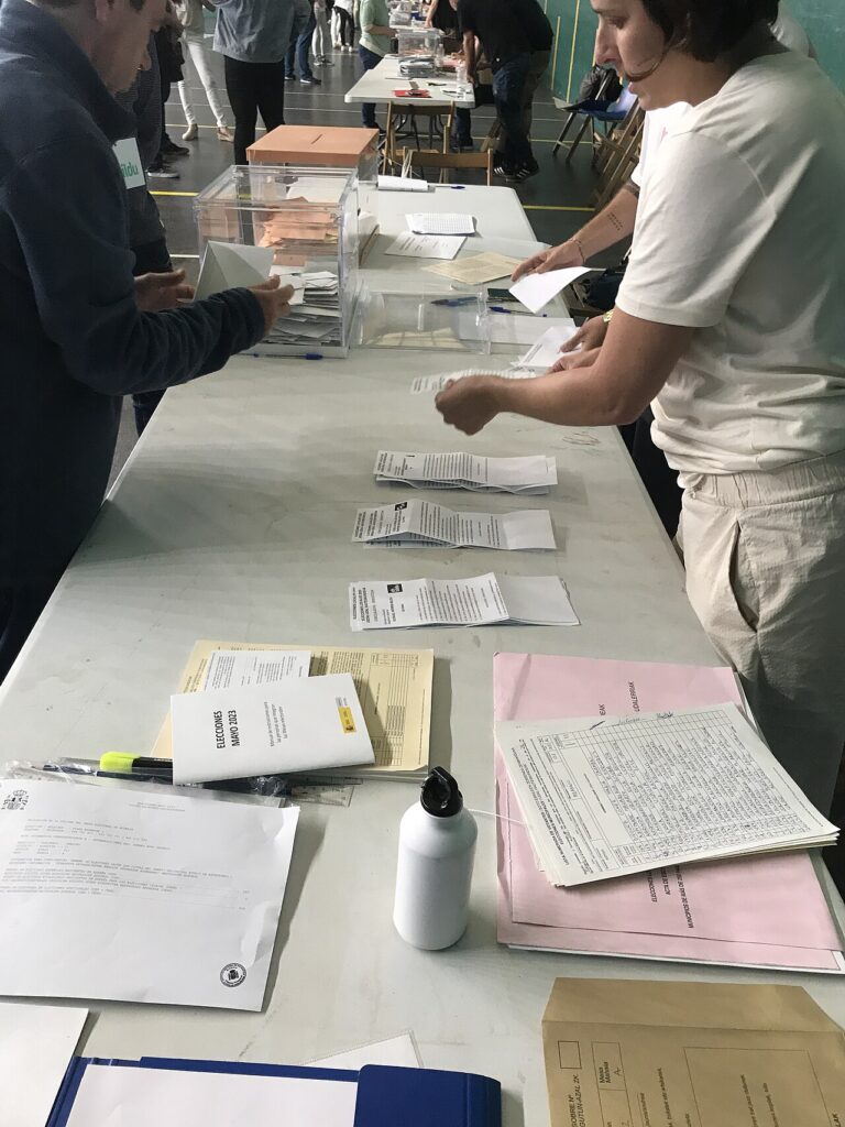 Papeletas de distintas candidaturas sobre una mesa de un colegio electoral